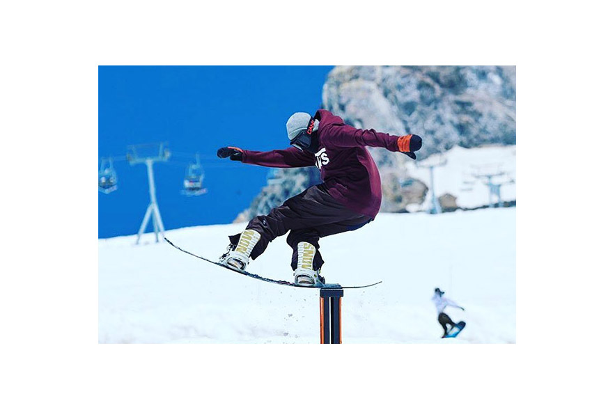 snowboarder riding down a rail
